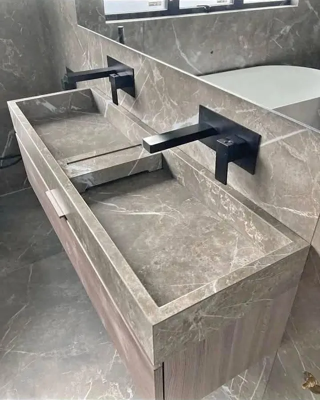 Encimera de lavabo efecto mármol gris instalada con grifo de pared negro