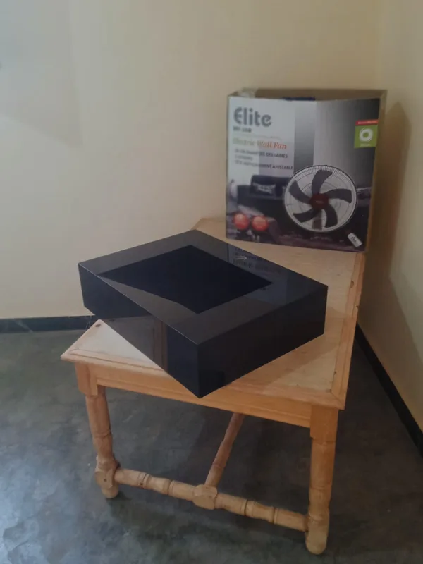 Lavabo cuadrado negro sobre una mesa de madera