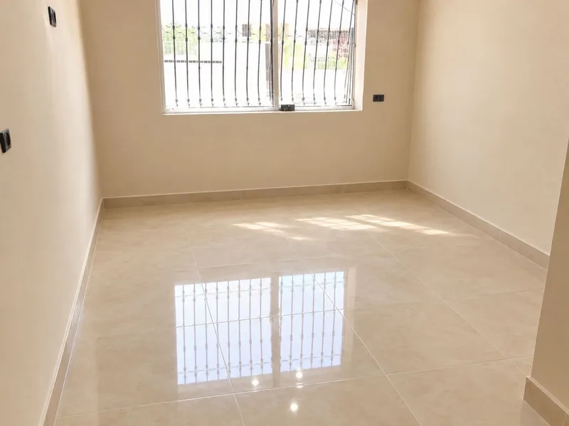 Sol en grands carreaux beige brillants avec plinthes